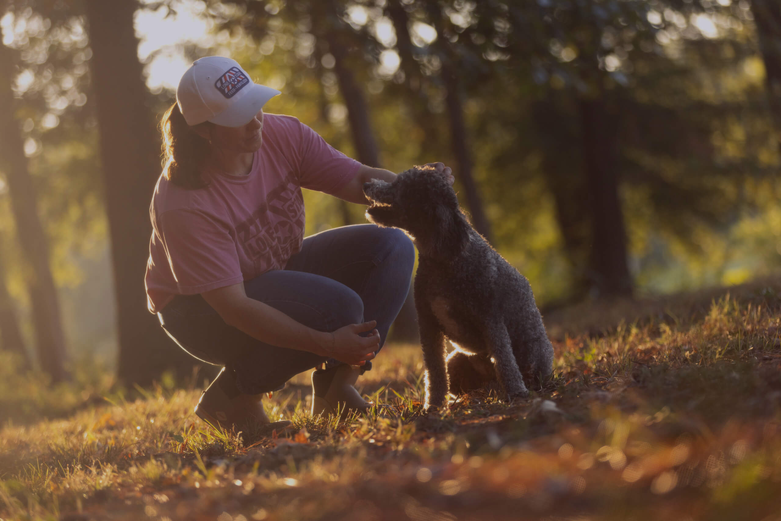 woman bent down petting a dog
