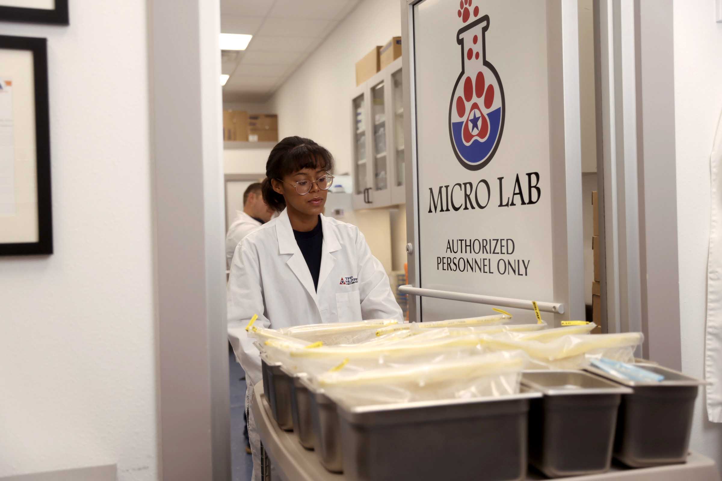 micro lab scientist with cart of bagged samples